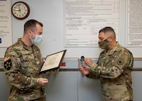 Joint Task Force Civil Support (JTF-CS) Commanding General Maj. Gen Jeffrey Van presents a certificate of appreciation and command coin to Army Lt. Col. Jason Faulkenberry, the commanding officer of McDonald Army Health Center, for his work supporting JTF-CS personnel COVID-19 vaccinations 11-13 January at the health center. JTF-CS members were able to take the vaccine on a voluntary basis in order to mitigate risk to military operations and increase mission readiness should the command be called upon to respond to an all-hazard defense support to civil authorities mission.