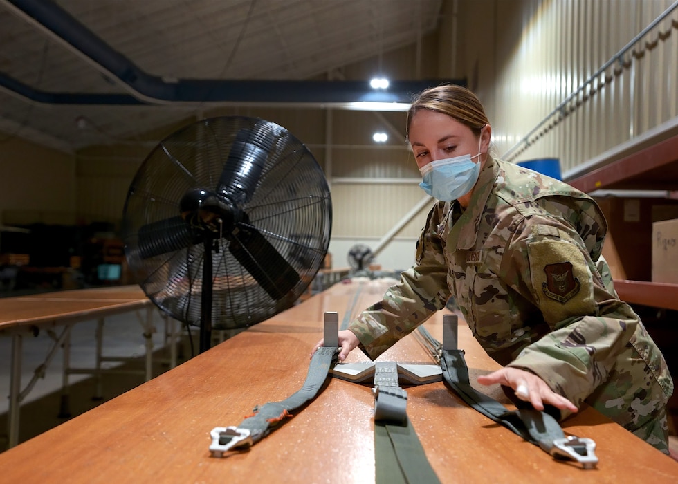 Staff Sgt. Makenzie Carlson, 919th Special Operations Logistic Readiness Squadron air transportation specialist, secures parachute straps to an untangling mechanism at Duke Field, Florida, Dec. 29, 2020.