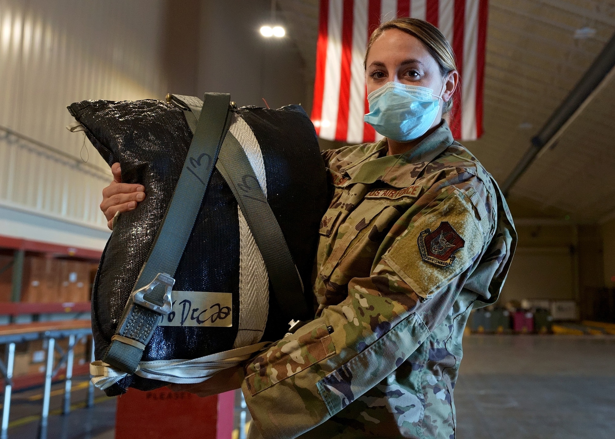 Staff Sgt. Makenzie Carlson, 919th Special Operations Logistic Readiness Squadron air transportation specialist, poses with a freshly packed parachute at Duke Field, Florida, Dec. 29, 2020.