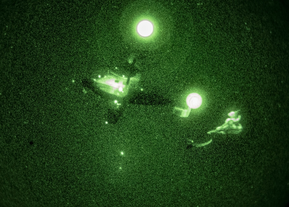 A C-145A Skytruck drops a hand-toss bag rigged to a parachute 