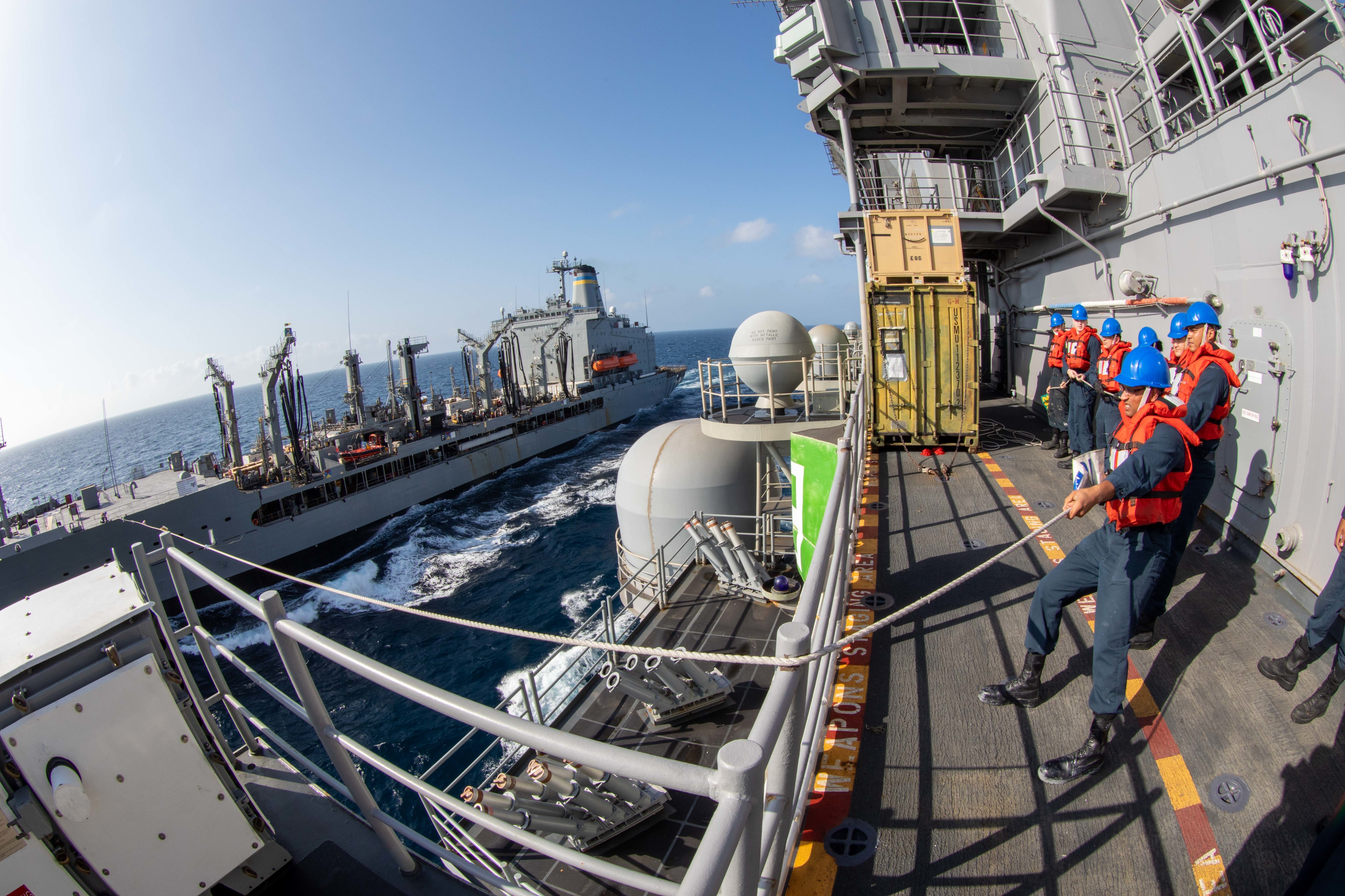 Sailors heave a line aboard the amphibious assault ship USS Makin Island (LHD 8) during a replenishment-at-sea with the fleet replenishment oiler USNS Big Horn (T-AO 198).