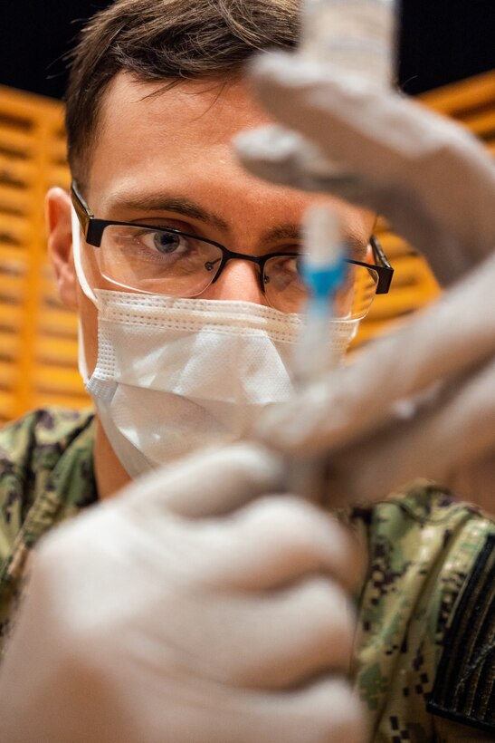 Military medical personnel administer COVID-19 vaccines.