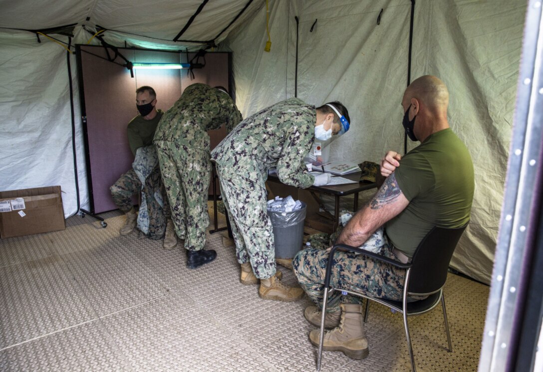 U.S. Marine Corps Brig. Gen. Kyle Ellison, left, III Marine Expeditionary Force deputy commanding general and U.S. Navy Master Chief Petty Officer Christopher W. Moore, right, III MEF command master chief, receive the COVID-19 vaccine at the U.S. Naval Hospital Okinawa, Camp Foster, Okinawa, Japan, Jan. 12, 2021. III MEF leadership received their vaccines as part of DoD’s phased approach to remain a lethal and ready expeditionary fighting force. (U.S. Marine Corps photo by Cpl. Francesca Landis)