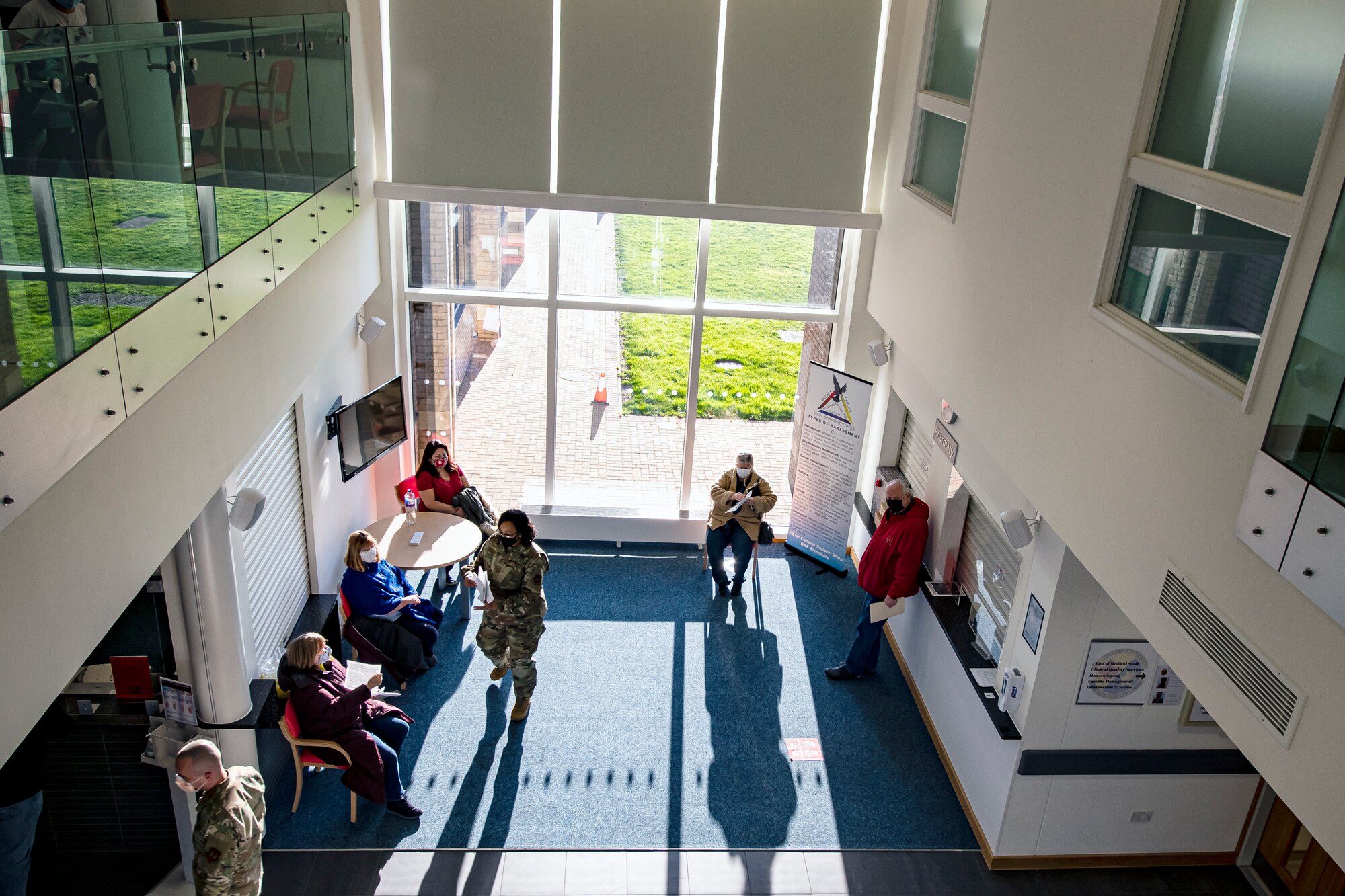 Department of Defense Education Activity teachers, wait in the lobby of the 423rd Medical Squadron clinic, prior to receiving the COVID-19 vaccine at RAF Alconbury, England, Jan. 7, 2020. DoDEA teachers are receiving the vaccine in an effort to reduce the potential spread of COVID-19 within the schools and community. (U.S. Air Force photo by Senior Airman Eugene Oliver)