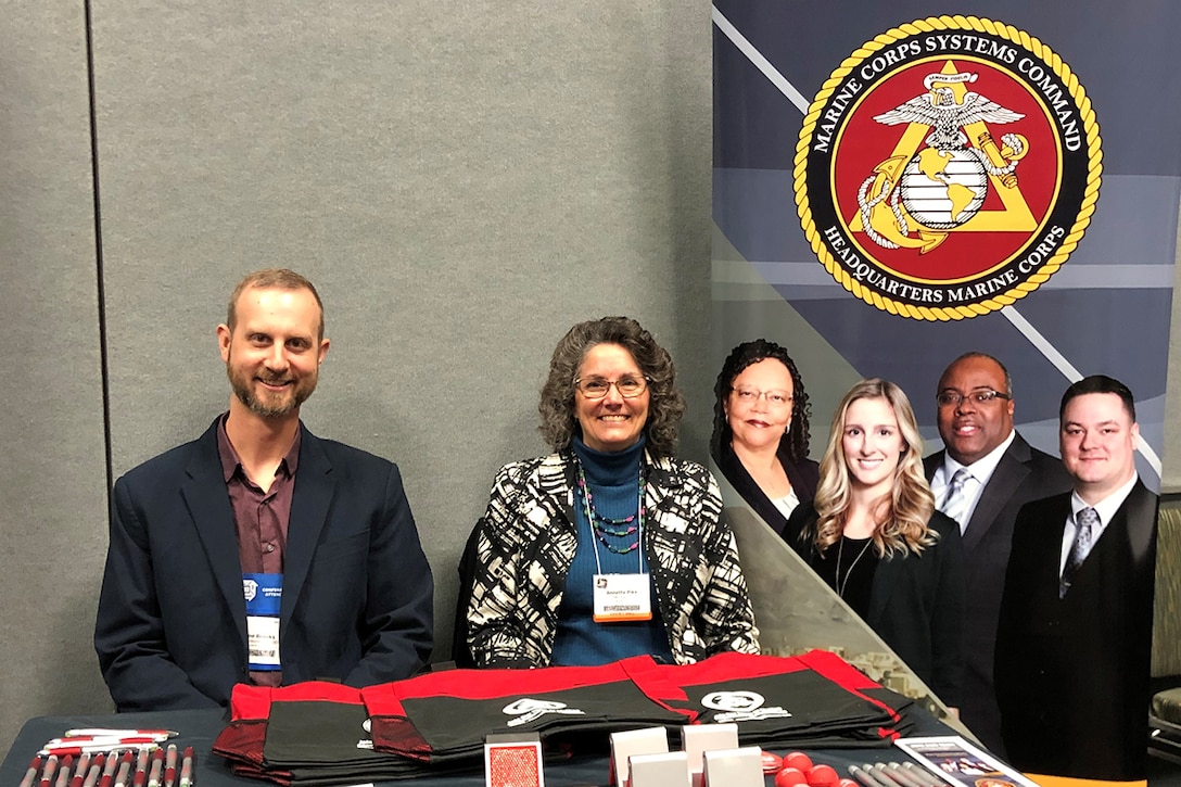 The division head for Marine Corps Systems Command’s Manpower and Services and an assistant program manager for the Program Manager for Training Systems, impart information about Human Resources to passersby in Orlando, Fla., Dec. 6.