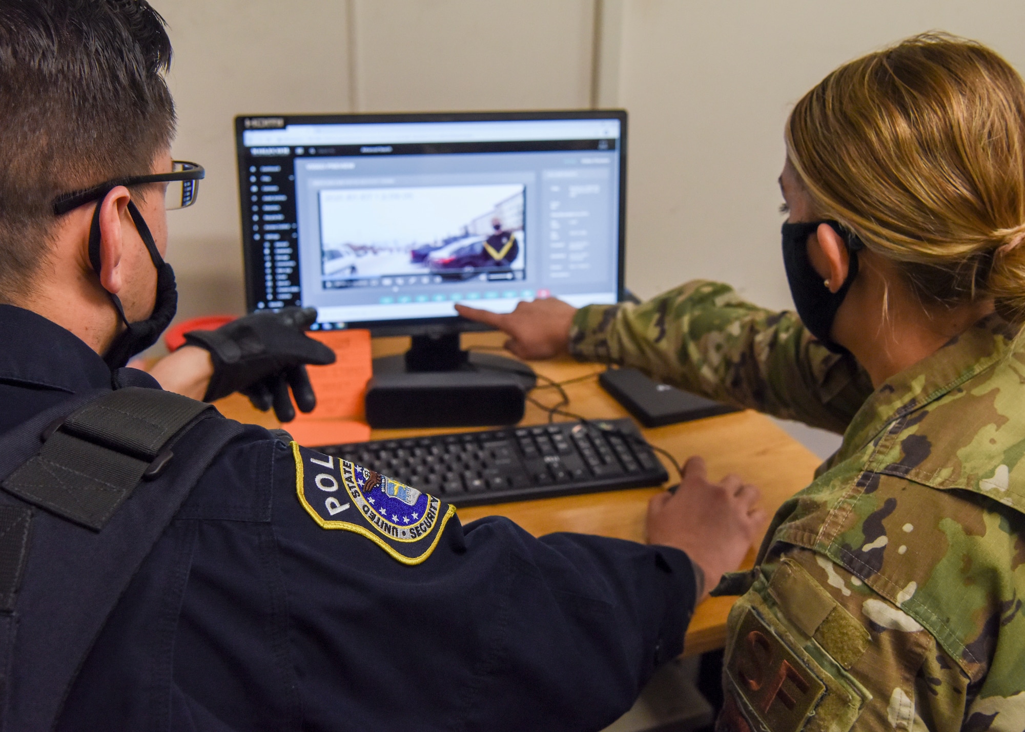 Department of Defense Police Officer Richard Martinez, patrol officer with the 673d Security Forces Squadron and U.S. Air Force Senior Airman Danielle Chose, a 673 SFS operations support/police services operator, review footage from a new body camera after an incident Jan. 8, 2021, at Joint Base Elmendorf-Richardson, Alaska. The 673d SFS has begun integrating 60 new, high-tech body cameras into daily operations after the adaptable technology reached a point of not only being a reliable safety and training instrument, but a multifunctional accountability tool serving all. (U.S. Air Force photo by Senior Airman Crystal A. Jenkins)