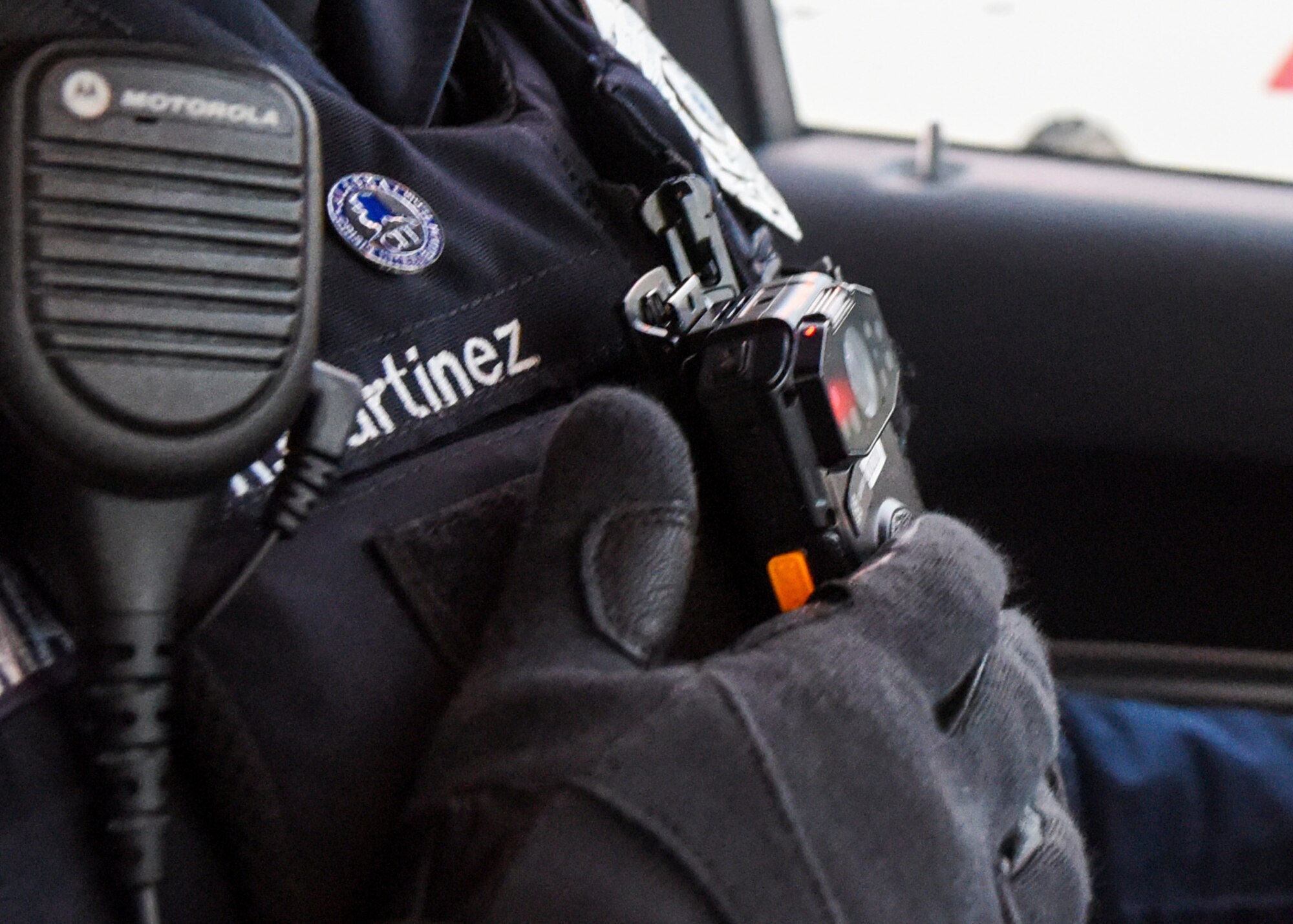 Department of Defense Police Officer Richard Martinez, a patrol officer with the 673d Security Forces Squadron turns on a new body camera during a routine stop Jan. 8, 2021, at Joint Base Elmendorf-Richardson, Alaska. The 673d SFS has begun integrating 60 new, high-tech body cameras into daily operations after the adaptable technology reached a point of not only being a reliable safety and training instrument, but a multifunctional accountability tool serving all. (U.S. Air Force photo by Senior Airman Crystal A. Jenkins)