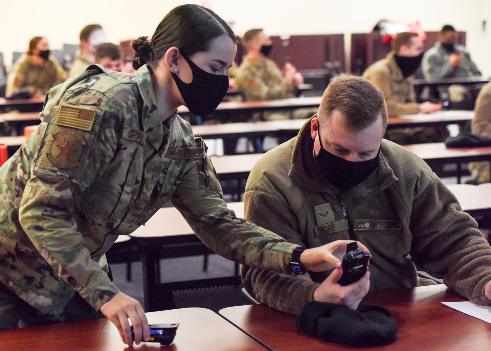 U.S. Air Force Airman 1st Class Kelly Griffith, a 673d Security Forces Squadron patrolman, and Senior Airman Joshua Moore, 673d SFS Alarm Monitor, become familiar with a new body camera device during a training day Jan. 6, 2021, at Joint Base Elmendorf-Richardson, Alaska. The 673d SFS has begun integrating 60 new, high-tech body cameras into daily operations after the adaptable technology reached a point of not only being a reliable safety and training instrument, but a multifunctional accountability tool serving all. (U.S. Air Force photo by Senior Airman Crystal A. Jenkins)