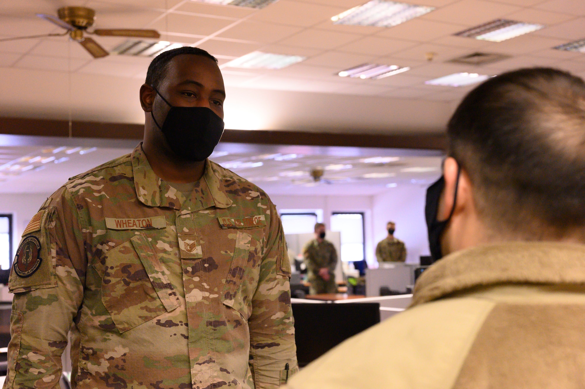 A photo of an Airman listening to another Airman.
