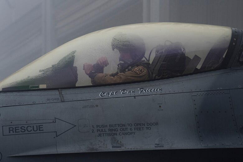 A pilot assigned to the 480th Expeditionary Fighter Squadron (EFS) signals a crew chief at Al Dhafra Air Base, United Arab Emirates, Jan. 19, 2021.