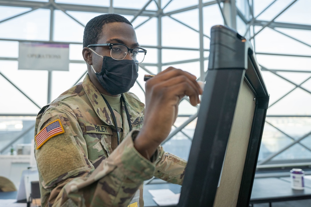 A soldier draws on a computer monitor.