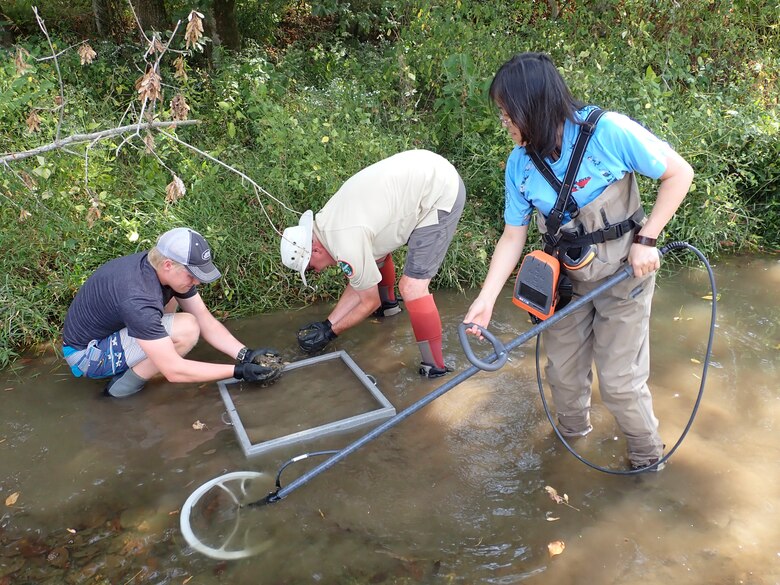 Dan Hua (Right), Tennessee Wildlife Resources Agency wildlife biologist and facility supervisor of the Cumberland River Aquatic Center in Gallatin, Tennessee; uses a device that recognizes tagged mussels, while Don Hubbs (Center), wildlife biologist and mussel recovery coordinator; and Jack Fetters, wildlife technician; sieve substrate to capture tagged mussels Oct. 1, 2019 at Lick Creek in Santa Fe, Tennessee. When the U.S. Army Corps of Engineers Nashville District lowered Lake Cumberland in Kentucky in 2008 to relieve pressure on Wolf Creek Dam, an agreement with the U.S. Fish and Wildlife Service to mitigate environmental impacts resulted in mitigation dollars being committed to the aquatic center. (Photo by Kristin Irwin)