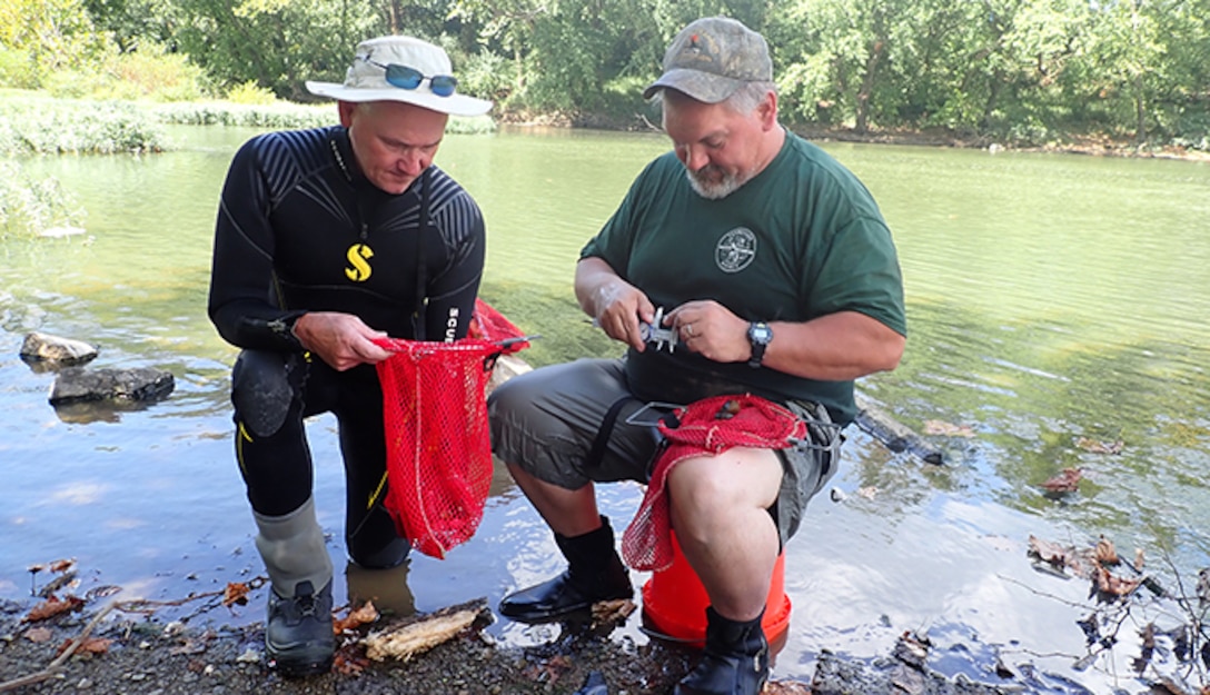 Jason Wisniewski (Right) and Don Hubbs, Tennessee Wildlife Resources Agency wildlife biologists, measure the size of recaptured mussels Sept. 17, 2019 at Lillards Mill on the Duck River in Lewisburg, Tennessee, as part of the recovery efforts of the Cumberland River Aquatic Center. When the U.S. Army Corps of Engineers Nashville District lowered Lake Cumberland in Kentucky in 2008 to relieve pressure on Wolf Creek Dam, an agreement with the U.S. Fish and Wildlife Service to mitigate environmental impacts resulted in mitigation dollars being committed to the aquatic center. (Photo by Dan Hua)