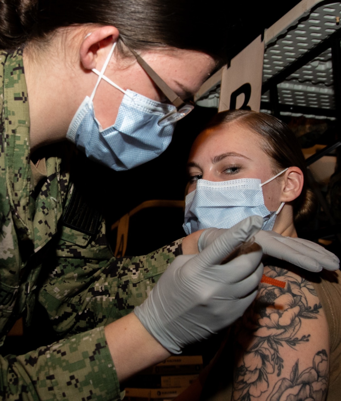 NAVAL STATION ROTA, Spain (Jan. 15, 2021) Hospital Corpsman 3rd Class Keira Woodward receives the Moderna COVID-19 vaccine from Hospitalman Anastasia Kennedy at Flix Theater, Naval Station Rota, Spain, on 15 January 2021. U.S. Naval Hospital (USNH) Rota has begun administering the vaccine to frontline healthcare and first responders as part of the vaccination campaign. (U.S. Navy photo by Mass Communication Specialist 1st Class Nathan Carpenter)