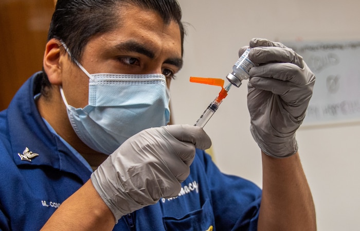 NAVAL STATION ROTA, Spain (Jan. 15, 2021) Hospital Corpsman 3rd Class Martin Covarrubias draws vaccine into a syringe from a vial from the first coronavirus (COVID-19) vaccine shipment to U.S. Naval Hospital (USNH) Rota, Spain on 15 January, 2021. The vaccine will be administered in phases based on priority levels to reduce the burden of COVID-19 in high-risk populations and simultaneously mitigate risk to military operations. (U.S. Navy photo by Mass Communication Specialist 1st Class Nathan Carpenter)