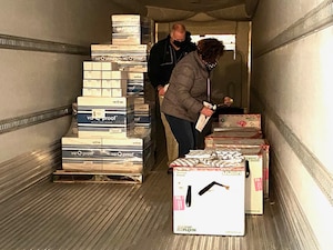 Defense Logistics Agency Distribution Susquehanna employees-Jenny Potts and George Hillman inspect Moderna COVID-19 packages inside the cold storage unit as the vaccines are prepared for shipment to overseas troops and the Navy Fleet.
