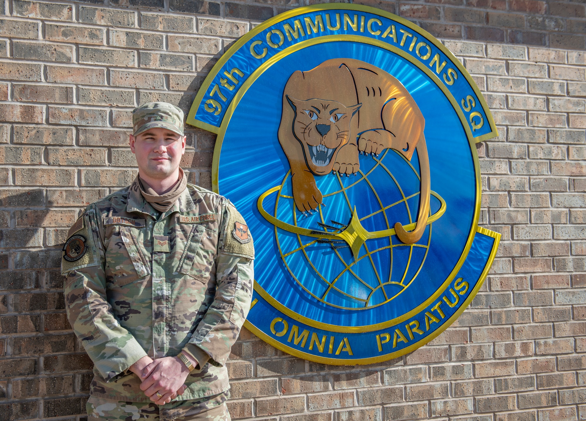 Senior Airman Carson Dotson, 97th Communications Squadron (CS) cyber transport systems journeyman, stands next to the 97th CS logo on Jan. 20, 2020, at Altus Air Force Base, Oklahoma. The application period for eligible Airmen to transfer into the U.S. Space Force opened on May 1, 2020 while Dotson was deployed to Kuwait. Despite the distance, he was still able to work with his Altus leadership and get his application submitted in time for the cut off. (U.S. Air Force photo by Airman 1st Class Amanda Lovelace)