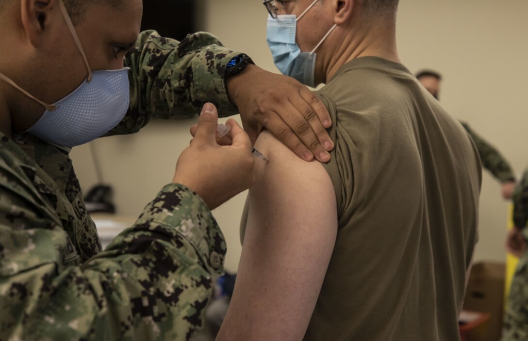 U.S. Army Lt. Col. Charles Calio, the public affairs officer deployed with Task Force 46, headquartered in Lansing, Mich., receives the Pfizer COVID-19 vaccine at the Navy Hospital at Camp Pendleton in Oceanside, California.