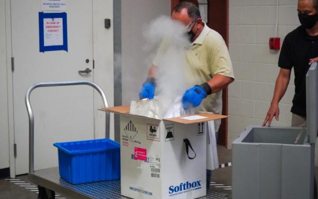 Norberto Seda-Ortiz, with Tripler Army Medical Center's Logistics Division, unpacks the COVID-19 vaccine shipment from it's dry ice container.