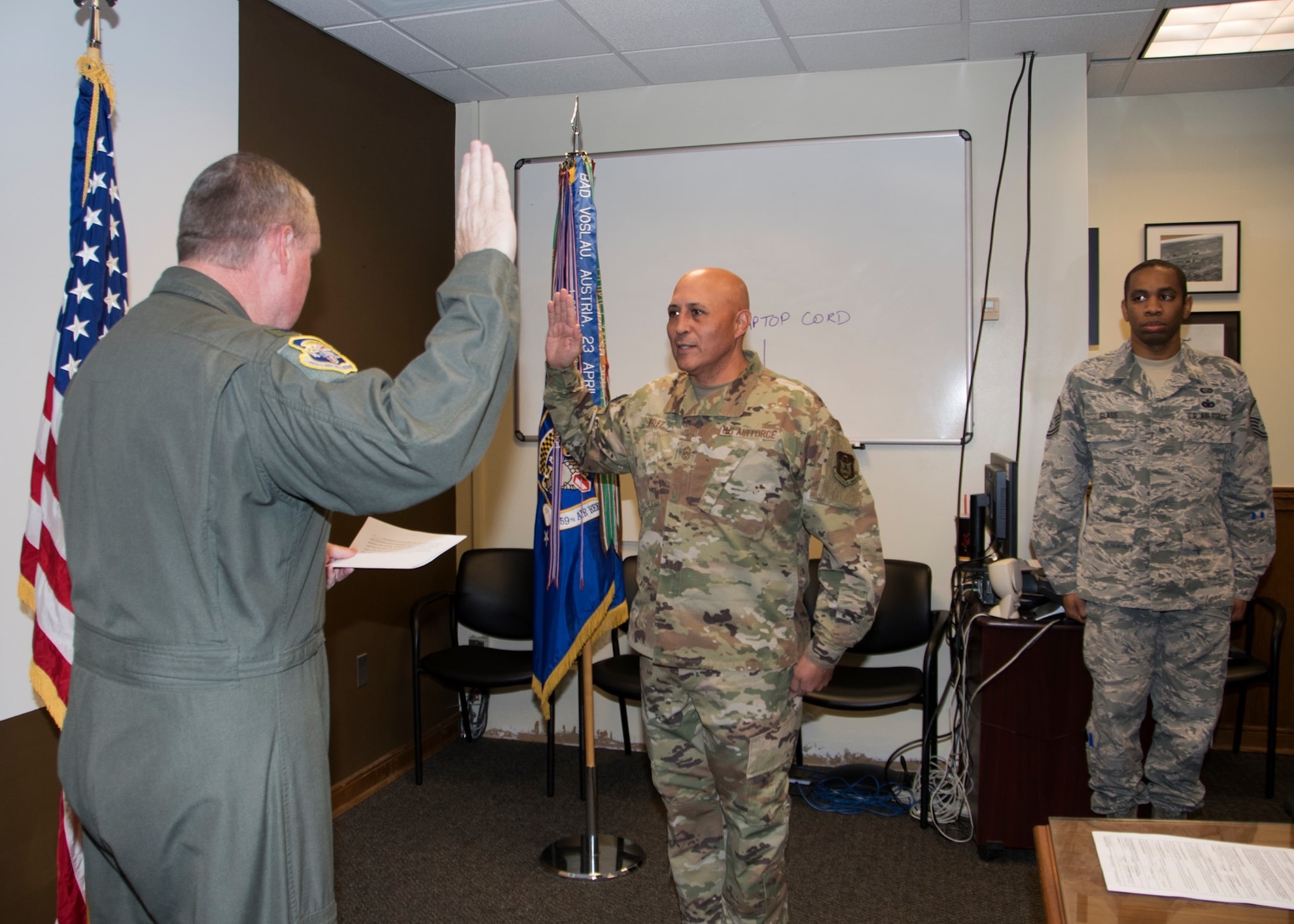 Chief Jose Velez Jr. former 459th Air Refueling Wing Command Chief, reenlists for the last time with former 459 ARW commander, Col. Doug Gullion. Velez will complete 26 years of military service on Feb. 28, 2021. (U.S. Air Force photo by Staff Sgt. Cierra Presentado/Released)