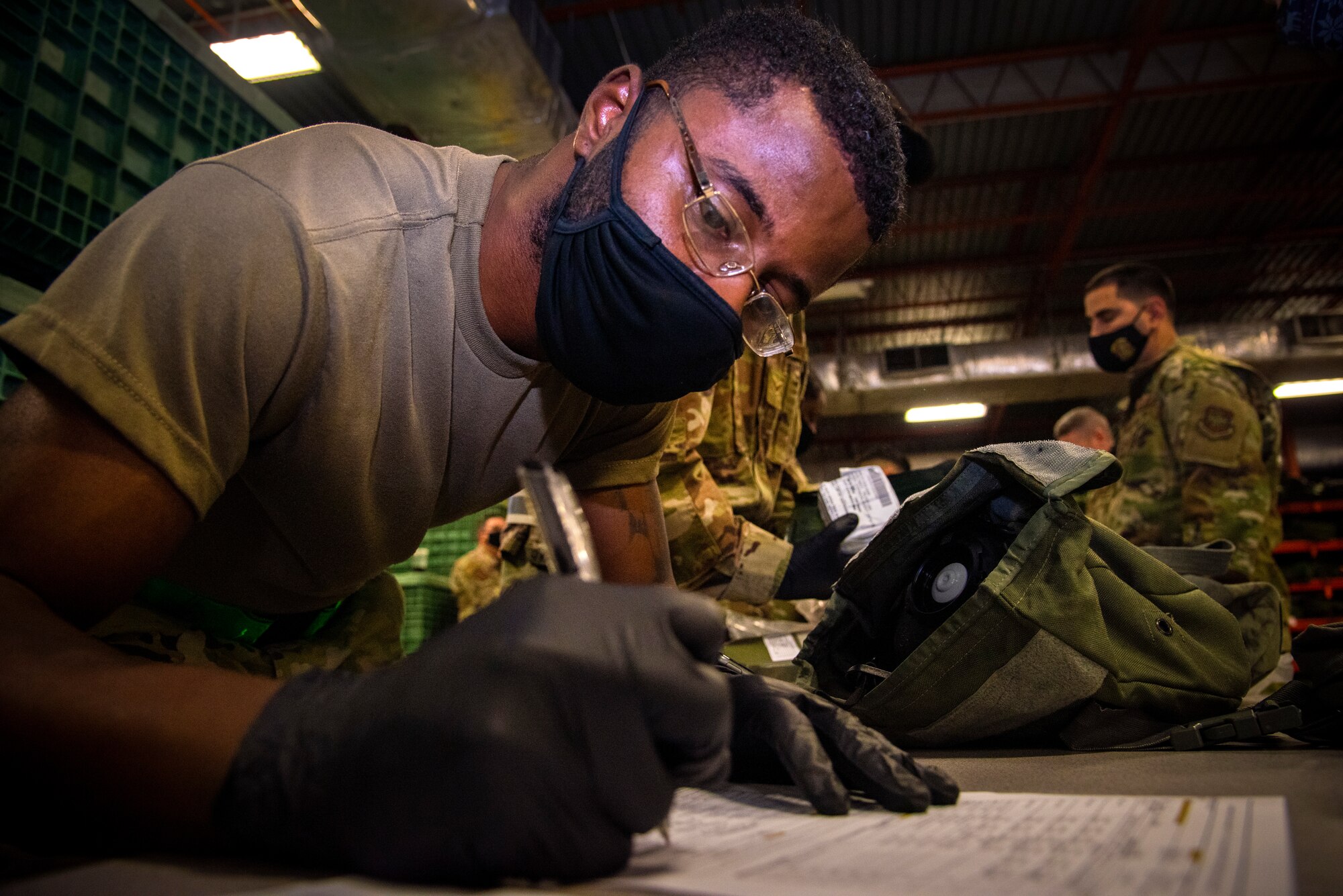 Airman 1st Class Martre Williams, a 6th Logistics Readiness Squadron individual protective equipment technician, issues out gear for a personnel deployment function during a large-scale readiness exercise (LRE) at MacDill Air Force Base, Fla., Jan. 11, 2021.