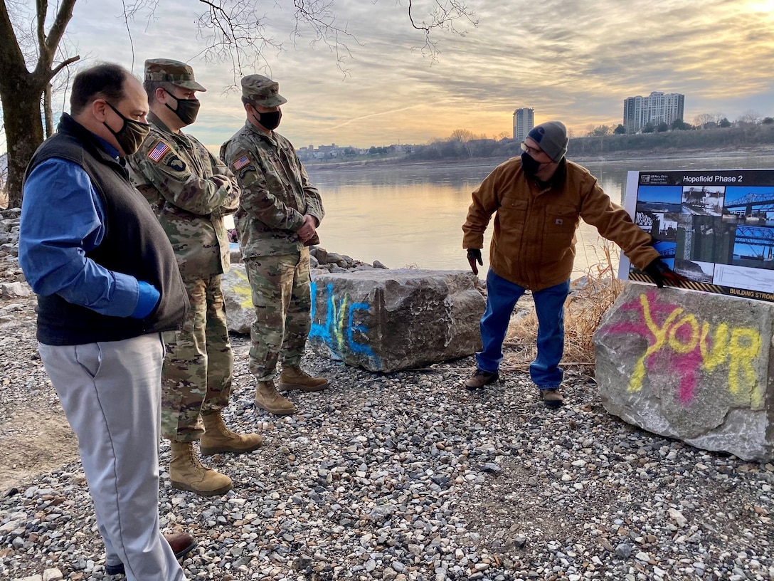 IN THE PHOTOS, Project Manager Mark Mazzone briefs Memphis District Commander Col. Zachary Miller and other district leadership on the details of the Hopefield project at the exact site where the armoring took place. Afterward, the group walked down to the riverbank to cut the ribbon, symbolizing the victory and celebration of completing yet another significant project. (USACE photos by Jessica Haas)