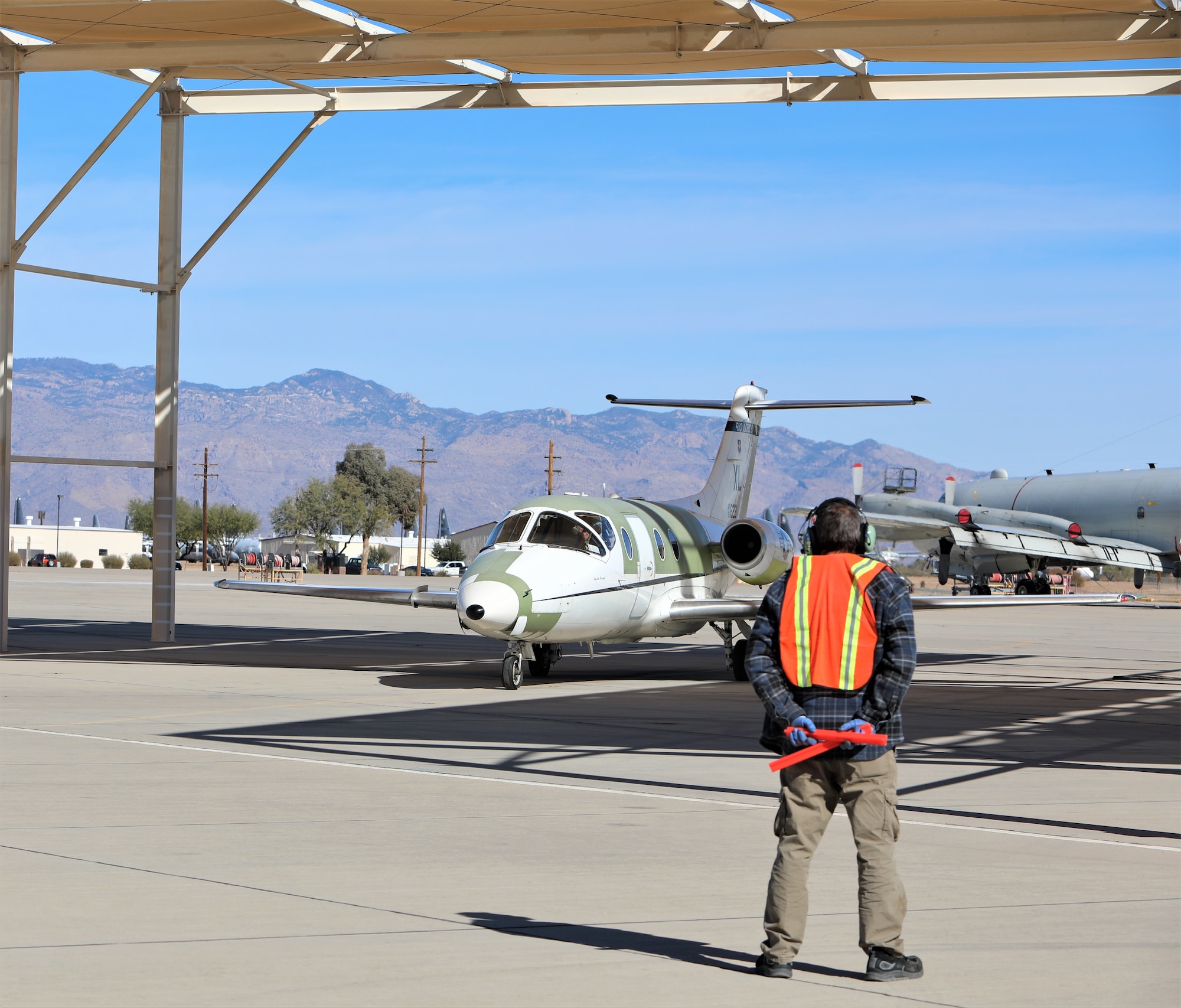 Chad Ellingson, 576th Aerospace Maintenance and Regeneration Squadron, marshals the last T-1A Jayhawk.