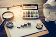 photo of piggy bank, clipboard and calculator.