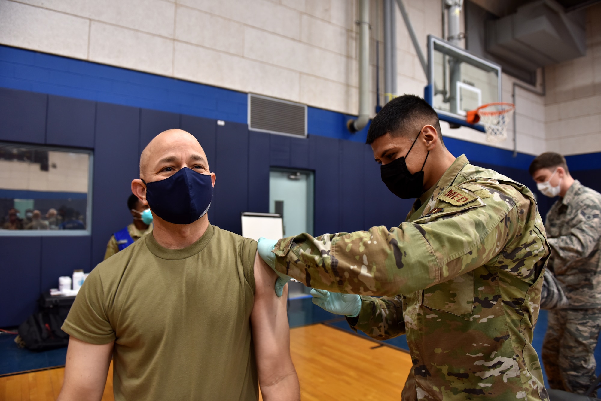 U.S. Air Force Airman 1st Class Benjamin Loera, 17th Operational Medical Readiness Squadron medical technician for active duty, administers the COVID-19 vaccine to Col. Andres Nazario, 17th Training Wing commander at the Mathis Fitness Center on Goodfellow Air Force Base, Texas, Jan. 22, 2021. On Jan. 20, Team Goodfellow vaccinated its frontline and mission essential positions and those who are considered high risk, first, in accordance with the Department of the Air Forces distribution plan. (U.S. Air Force photo by Staff Sgt. Seraiah Wolf)
