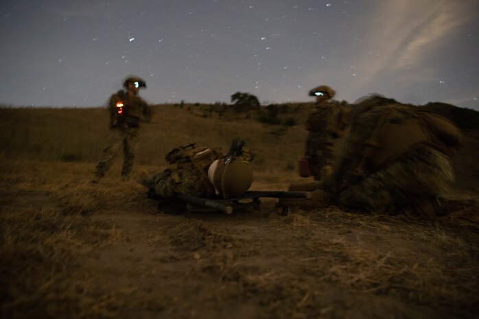 U.S. Marines with Bravo Company, Battalion Landing Team 1/1, 11th Marine Expeditionary Unit, provide aid to a simulated casualty during a Tactical Recovery of Aircraft and Personnel (TRAP) exercise at Marine Corps Base Camp Pendleton, California, Dec. 16, 2020. The purpose of the exercise was to familiarize the TRAP force with providing immediate response to isolated personnel in potential search and rescue situations, during both day and night scenarios. (U.S. Marine Corps photo by Sgt. Jennessa Davey)