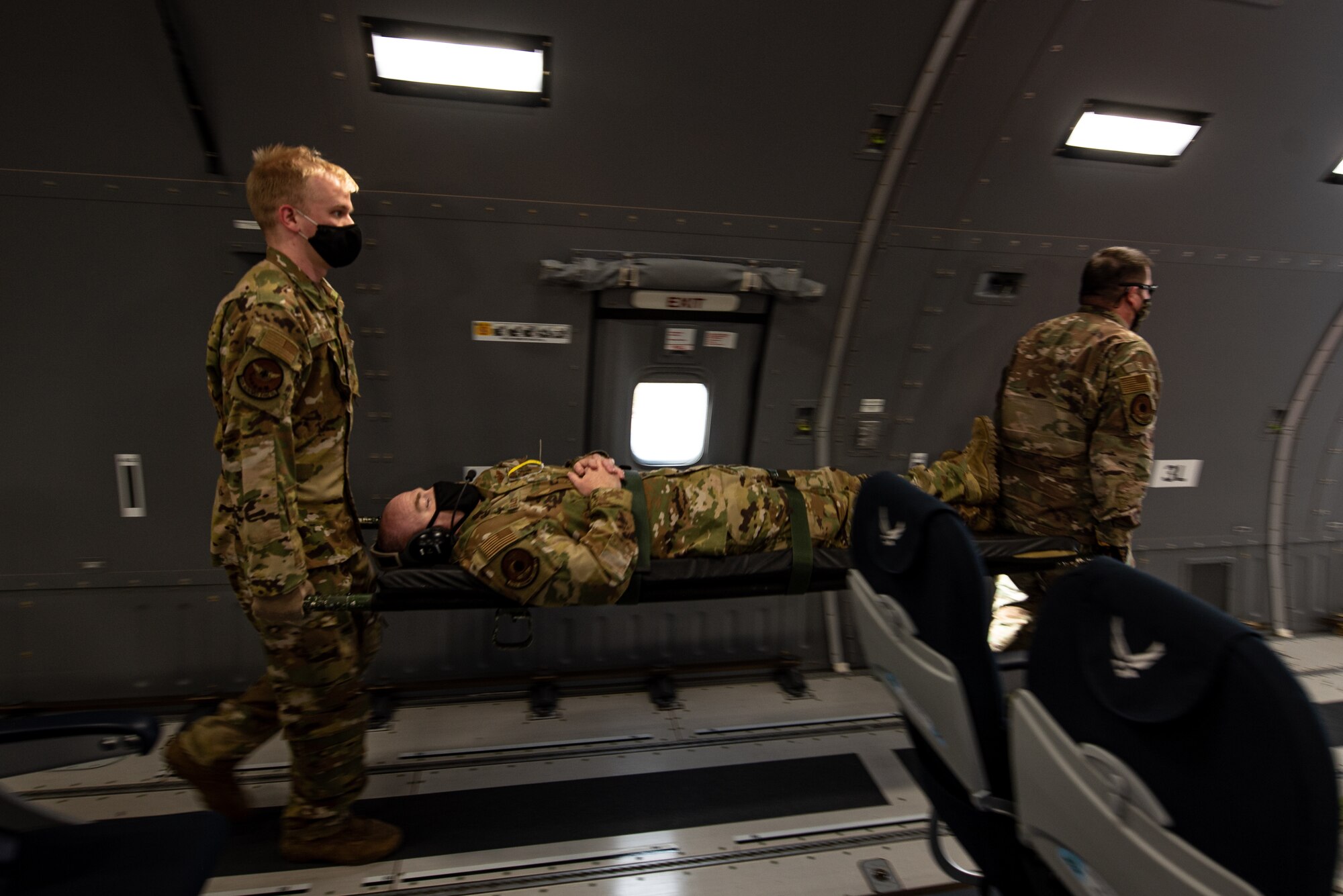 Airmen moving Airman on stretcher