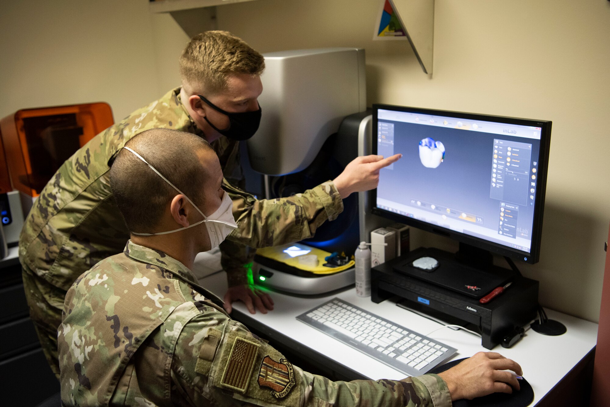 U.S. Air Force Airman 1st Class Colby Locke, left, 60th Dental Squadron dental laboratory technician, shows Col. Zachery Jiron, right, 60th Air Mobility Wing vice commander, the steps to create a crown inside David Grant USAF Medical Center during Leadership Rounds Jan. 22, 2021, at Travis Air Force Base, California. A crown is a cap used to cover a damaged tooth. The Leadership Rounds program provides 60th AMW leadership an opportunity to interact with Airmen and receive a detailed view of each mission performed at Travis AFB. (U.S. Air Force photo by Airman 1st Class Alexander Merchak)