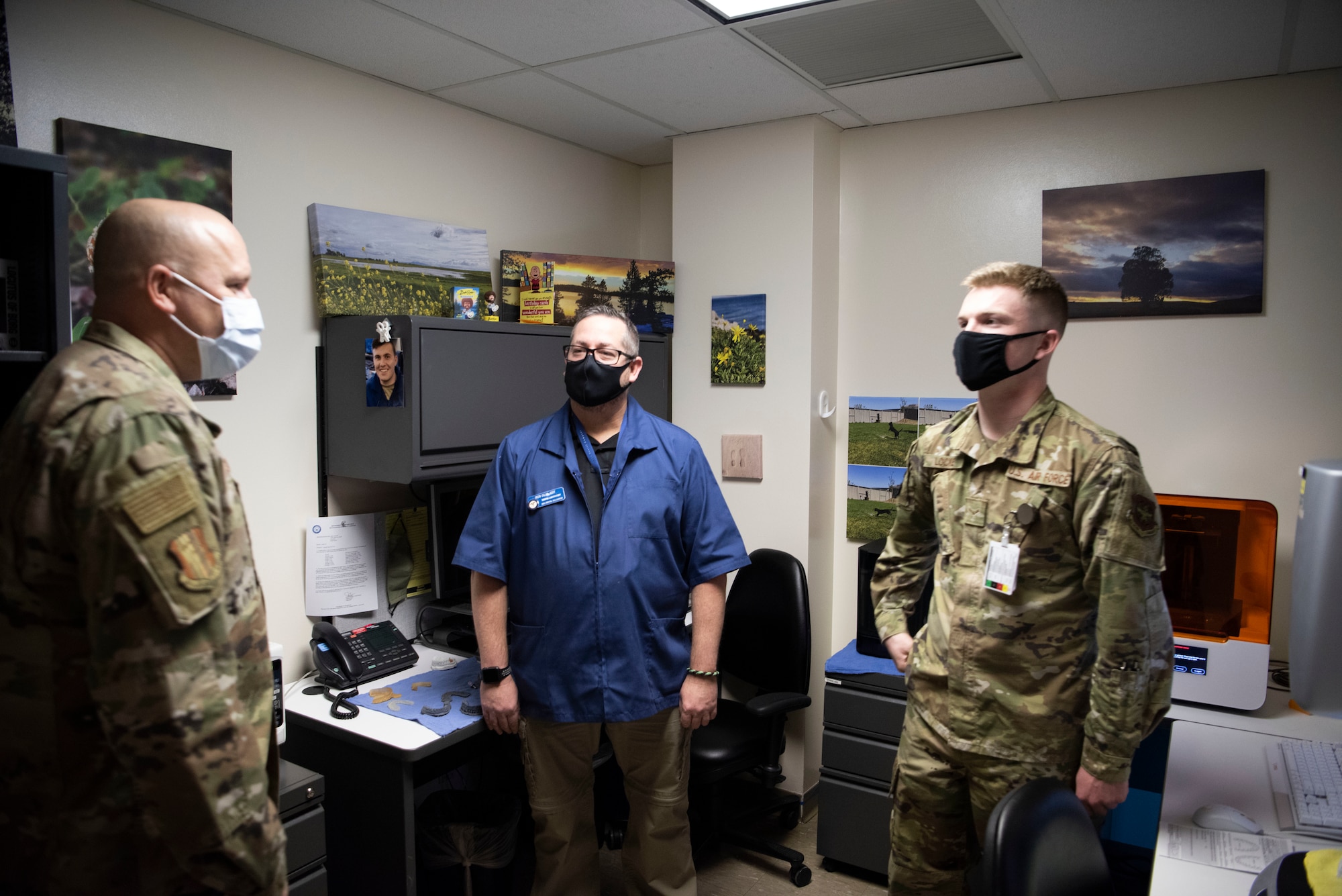 U.S. Air Force Chief Master Sgt. Robert Schultz, left, 60th Air Mobility Wing command chief, congratulates Robert Silva, center, 60th Dental Squadron dental laboratory technician, and Airman 1st Class Colby Locke, right, 60th DS dental laboratory technician, on being coined as star performers inside David Grant USAF Medical Center Jan. 22, 2021, at Travis Air Force Base, California, during Leadership Rounds. The Leadership Rounds program provides 60th AMW leadership an opportunity to interact with Airmen and receive a detailed view of each mission performed at Travis AFB. (U.S. Air Force photo by Airman 1st Class Alexander Merchak)