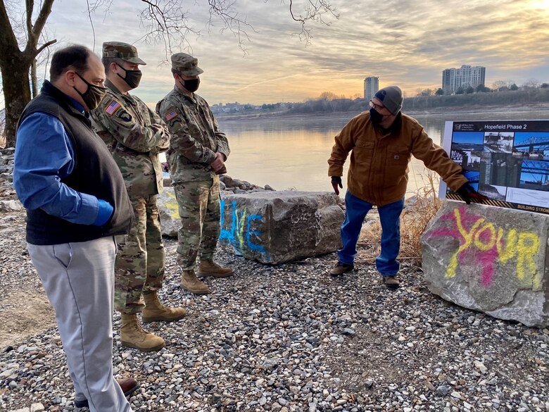 IN THE PHOTOS, Project Manager Mark Mazzone briefs Memphis District Commander Col. Zachary Miller and other district leadership on the details of the Hopefield project at the exact site where the armoring took place. Afterward, the group walked down to the riverbank to cut the ribbon, symbolizing the victory and celebration of completing yet another significant project. (USACE photos by Jessica Haas)