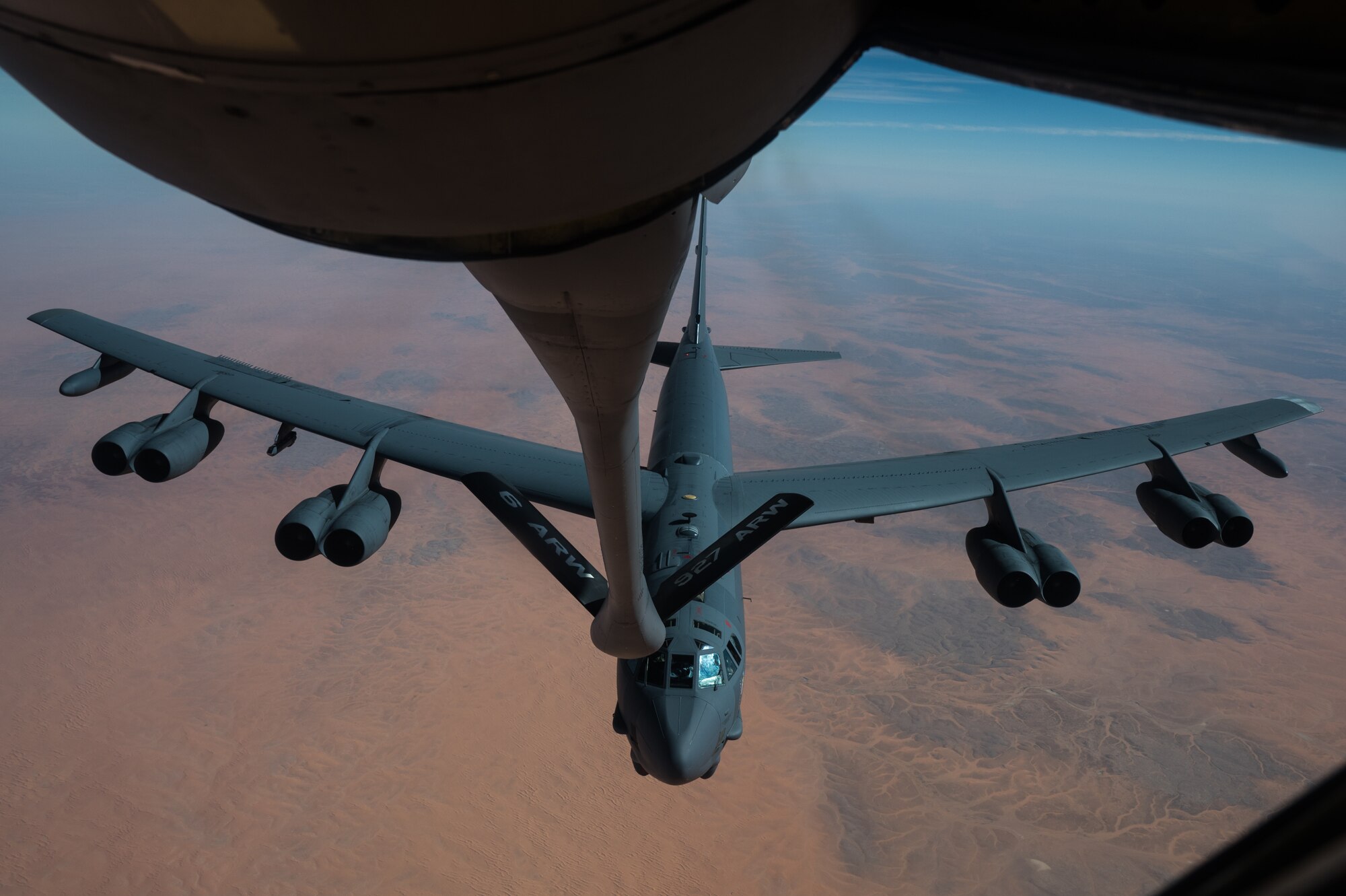 in-flight refueling specialist maneuvers the boom in order to provide fuel  to a B-52 Stratofortress during a bomber task force mission