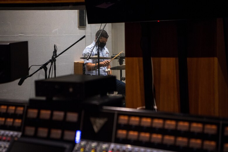 man plays drums in recording studio