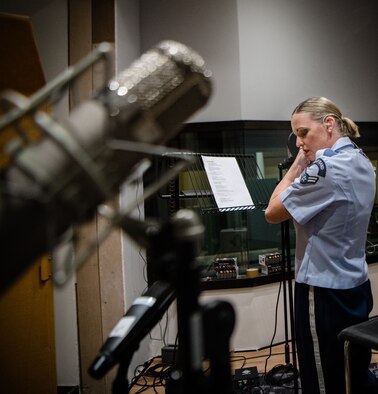 woman sings into microphone in recording studio