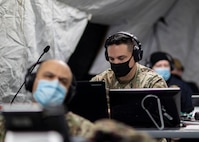 210123-N-PC620-0003 WILLIAMSBURG, Va. (Jan. 23, 2021) Army Maj. Jason De Los Santos, a Joint Task Force Civil Support Forward Command Element member, listens in on a commander's update brief inside a mobile command tent near a local hotel during Exercise Sudden Response 21.