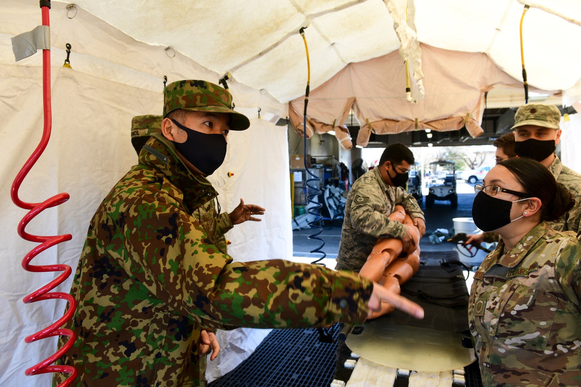 Japan soldier asks American Airman about training.