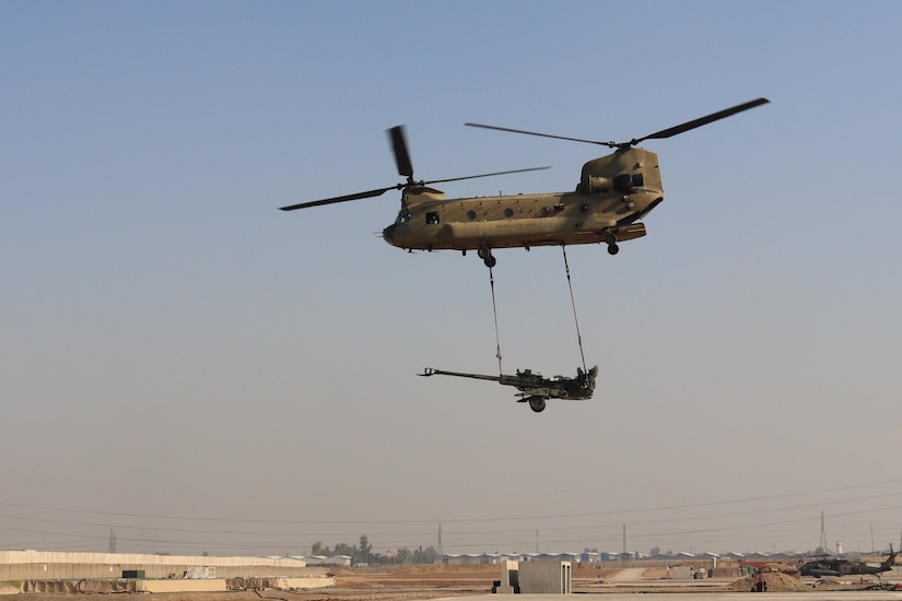 A CH-47 Chinook helicopter operated by Soldiers with Bravo Company, 3-238th General Support Aviation Battalion, 28th Expeditionary Combat Aviation Brigade sling loads an M777 Howitzer during an exercise with Soldiers with the 2-319th Field Artillery Regiment.