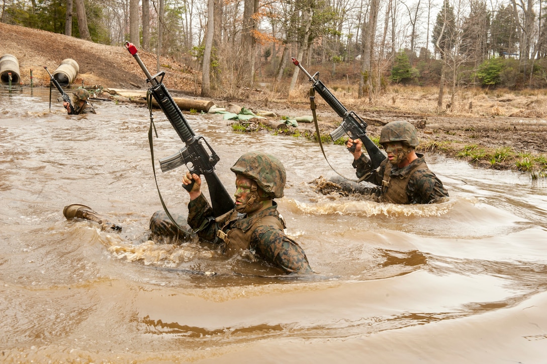 Candidates assigned to Delta Company, Officer Candidates Class-221, crawl through the murky water of 'The Quigley' at Brown Field, Marine Corps Base Quantico, Va., on March 15, 2016. The mission of Officer Candidates School (OCS) is to "educate and train officer candidates in Marine Corps knowledge and skills within a controlled, challenging, and chaotic environment in order to evaluate and screen individuals for the leadership, moral, mental, and physical qualities required for commissioning as a Marine Corps officer." (U.S. Marine Corps Photo by Cpl. Patrick H. Owens/Released)