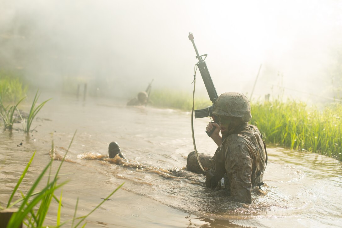 A candidate with the Officer Candidates School (OCS) crawls through “The Quigley” during the combat course at OCS, Marine Corps Base Quantico, Va., June 18, 2018. Candidates must go through three months of intensive training to evaluate and screen individuals for the leadership, moral, mental, and physical qualities required for commissioning as a U.S. Marine Corps officer. (U.S. Marine Corps Photo by Sgt. Jacqueline A. Clifford)