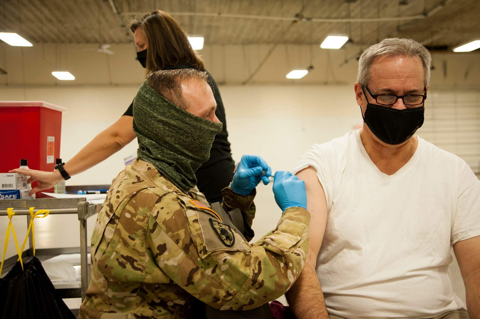 Nebraska National Guard Staff Sgt. Brad Wardyn, a flight medic with Company G, 2-104th General Support Aviation Battalion, administers the COVID-19 vaccine to Tom Kent, the resident and CEO for the Nebraska Public Power District, Jan. 21, 2021, in Columbus, Nebraska.