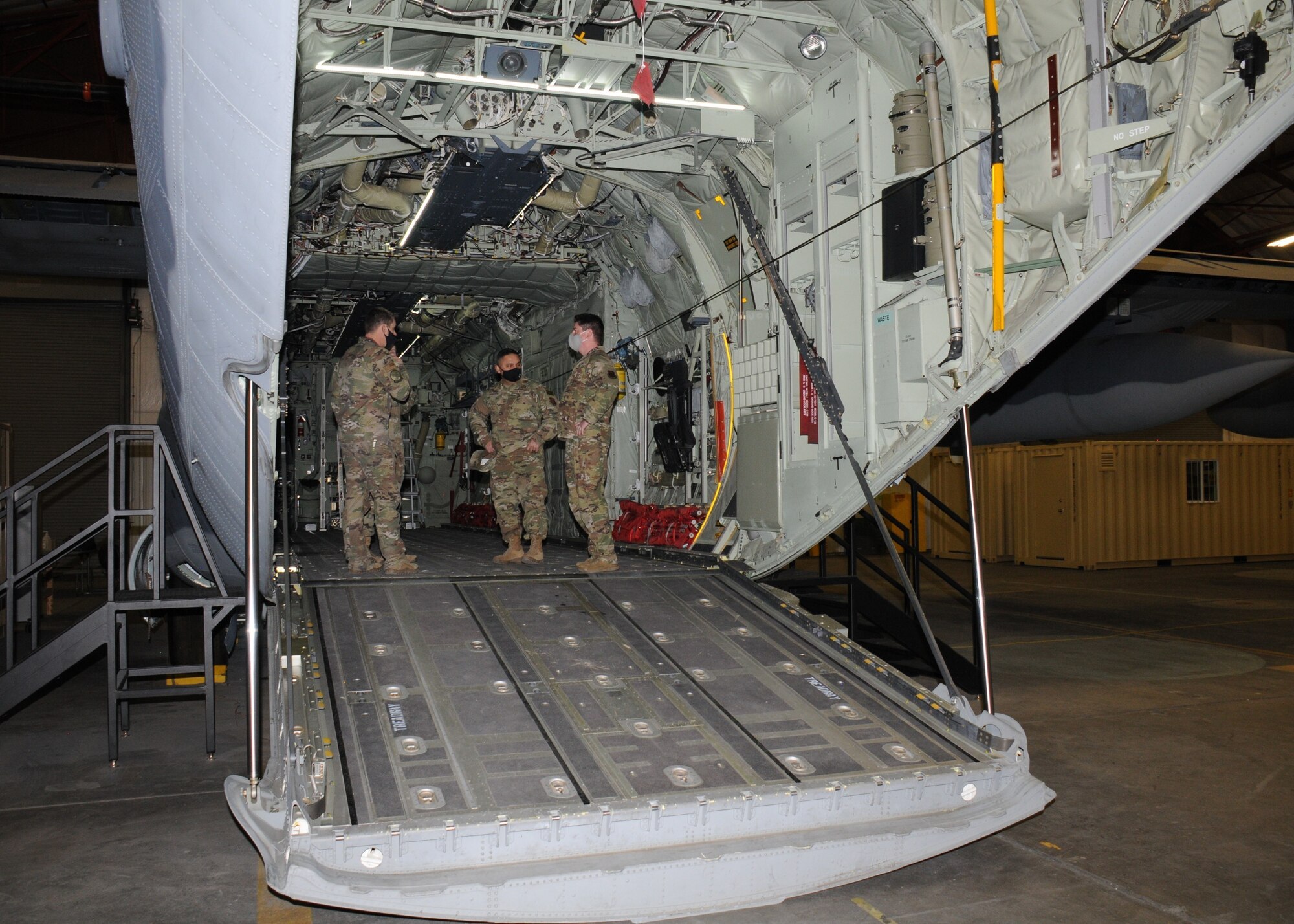 Three Airmen tour inside a C-130 ground training device.