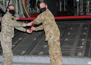 Two Air Force officers cut a ribbon to officially welcome a ground training device