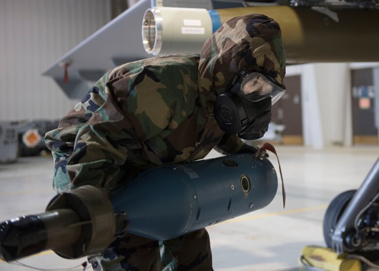 An US Air Force member lifts the guidance potion of a bomb.