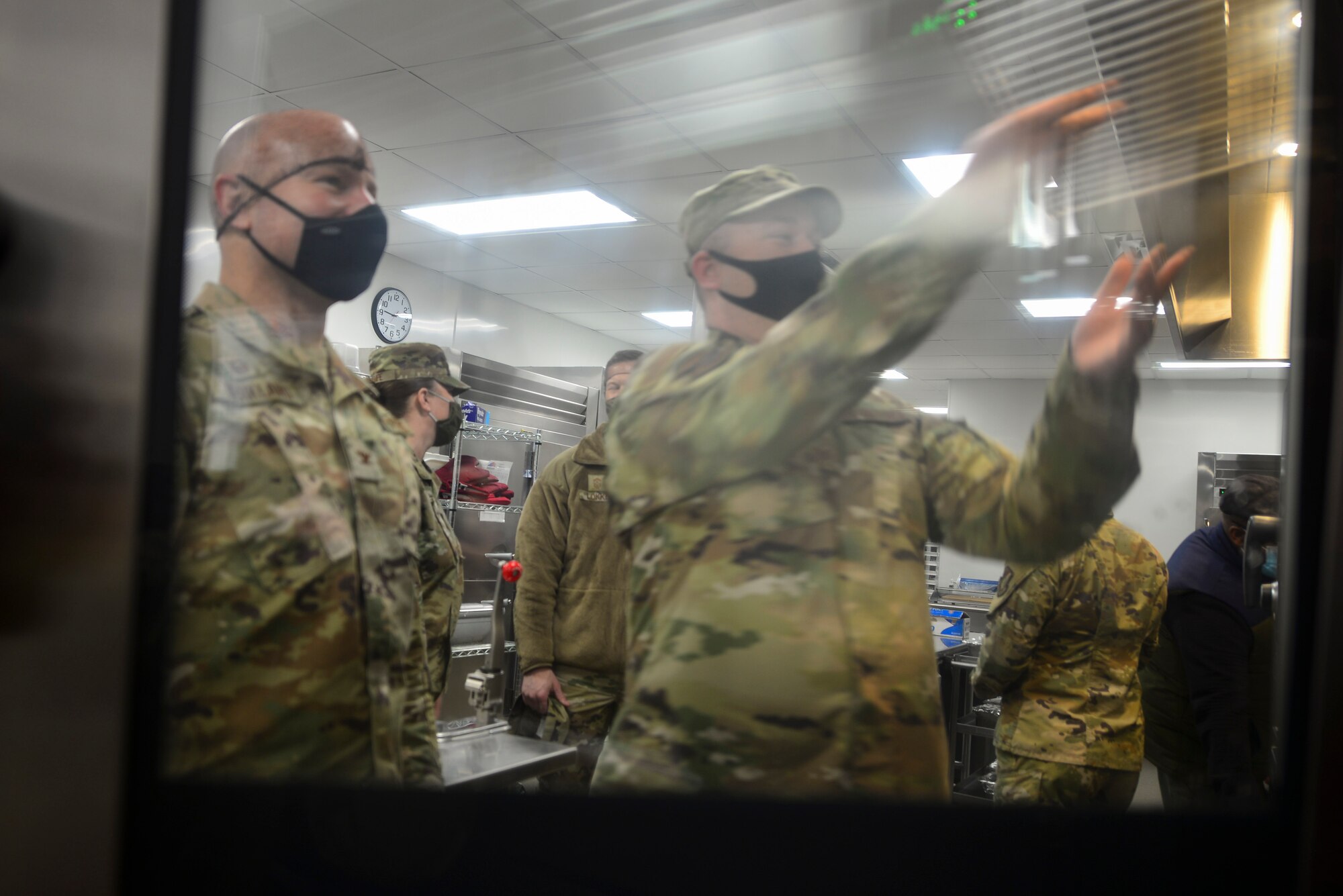 U.S. Air Force Tech. Sgt. Brian Vasvary, the 354th Force Support Squadron satellite dining facility (DFAC) manager, demonstrates how to operate a convection oven to Col. David Berkland, the 354th Fighter Wing commander on Eielson Air Force Base, Alaska, Jan 21, 2021.