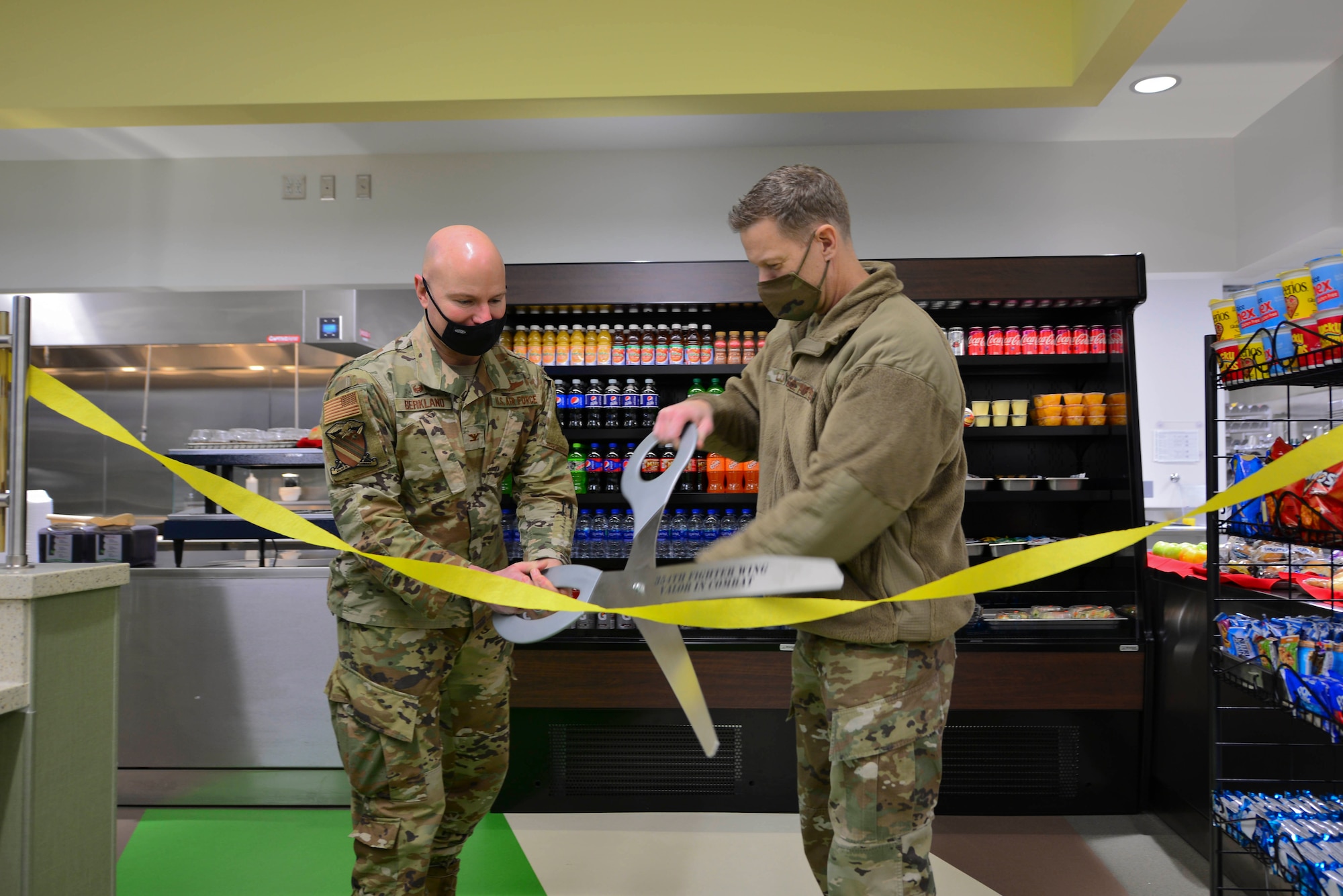 U.S. Air Force Col. David Berkland, the 354th Fighter Wing commander, and Chief Master Sgt. John Lokken, the 354th FW command chief, cut a ribbon during the reopening ceremony of the satellite dining facility (DFAC) on Eielson Air Force Base, Alaska, Jan 21, 2021.