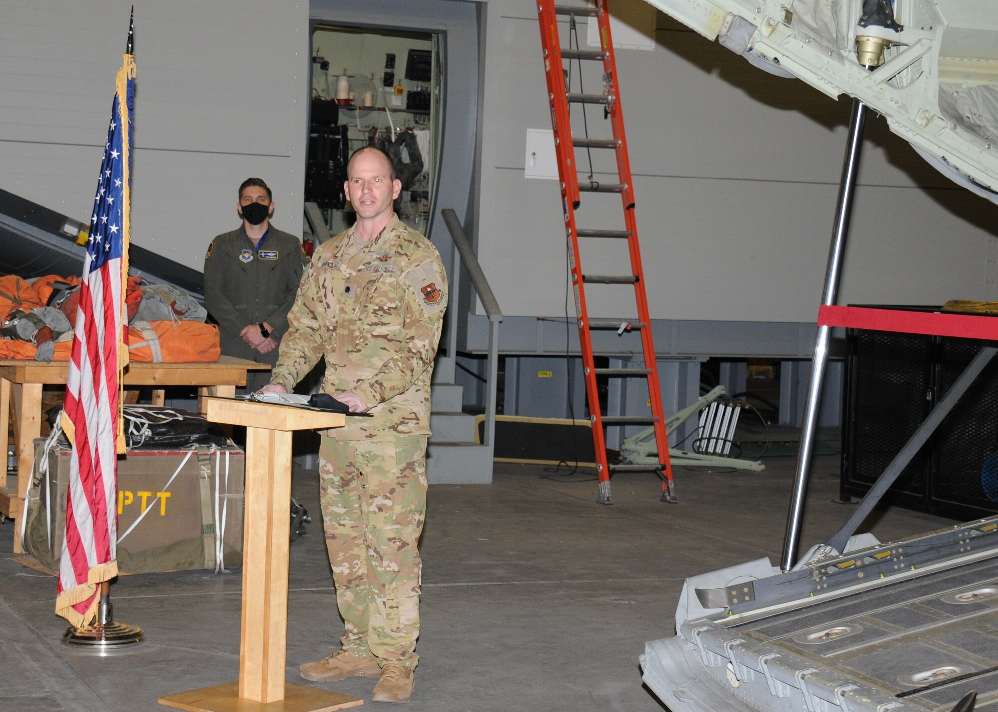 An Air Force officer speaks at a ribbon-cutting for a new ground training device.