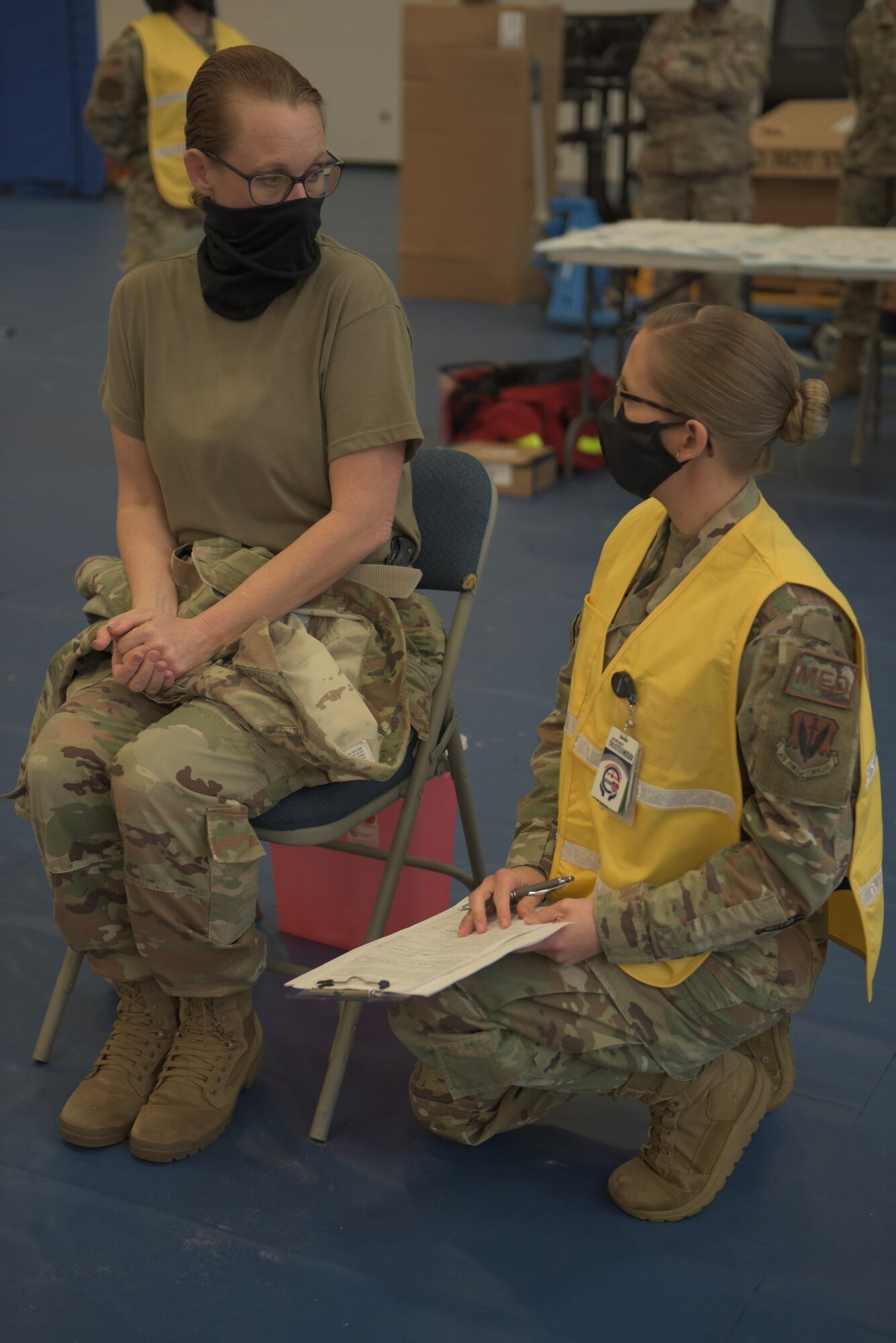 U.S. Air Force Chief Master Sgt. Kati Grabham, 325th Fighter Wing command chief, left, and Tech. Sgt. Haley Lecomte, 325th Operational Medical Readiness Squadron technician, right, discuss the Coronavirus vaccine prior to administration at Tyndall Air Force Base, Florida, Jan. 21, 2021. Each individual who received the vaccine was pre-briefed on what they could expect to experience once the vaccine had been administered. (U.S. Air Force photo by Staff Sgt. Magen M. Reeves)